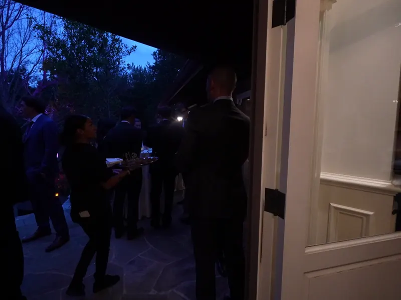 Evening reception with guests gathered around the catering setup in Campbell