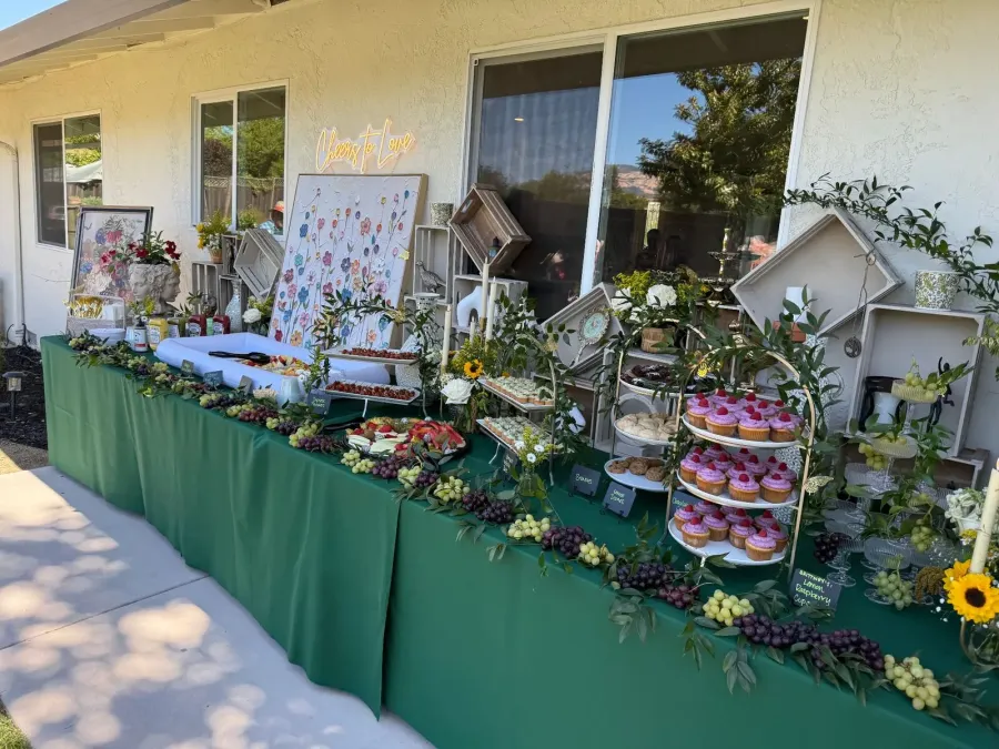 Shower sweets table dressed with soft neutral linens, cupcakes, berries and low bud vases as guests raise glasses — shower florals in Los Gatos