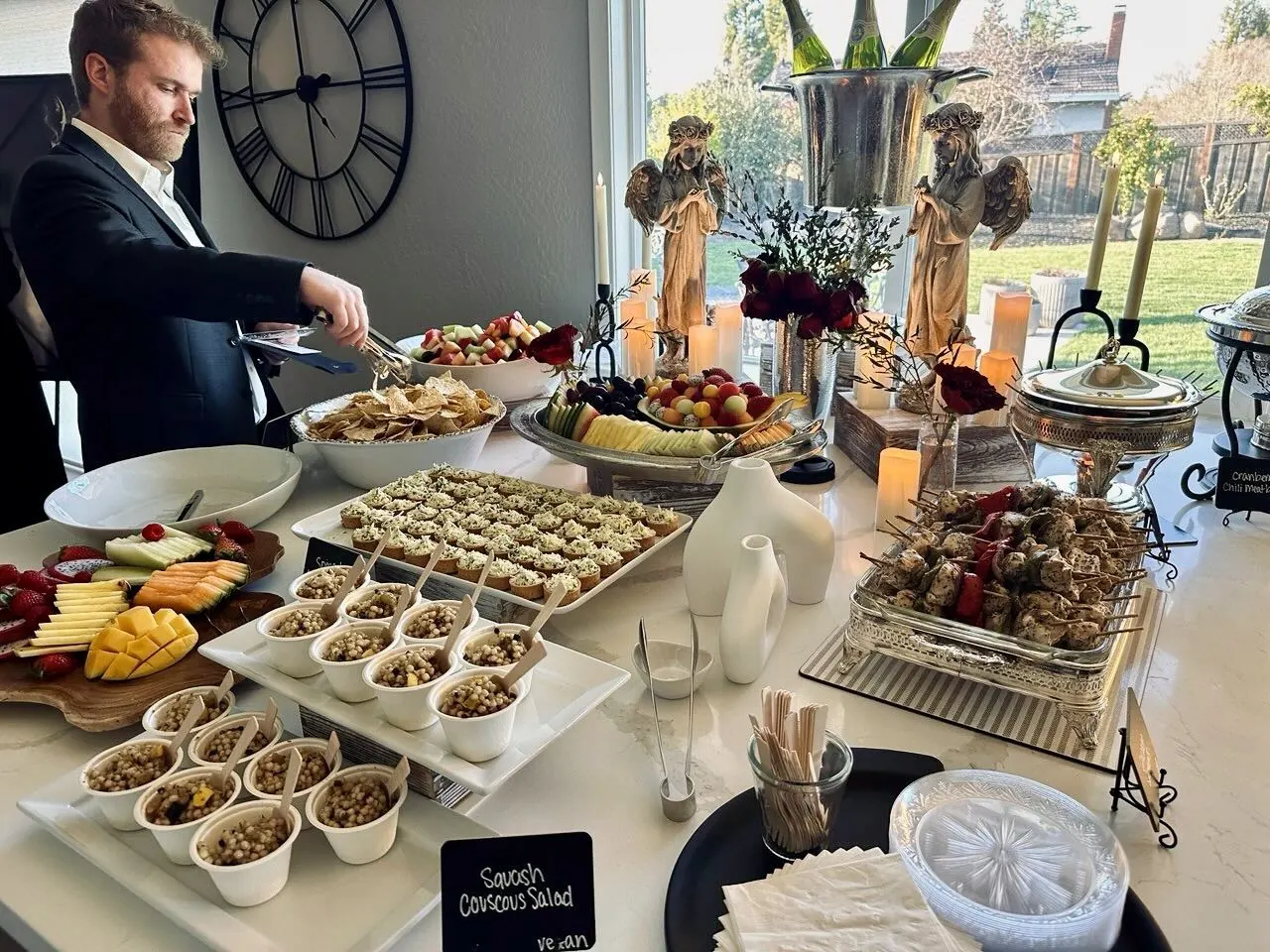 Elegant buffet with salads, skewers, and fruit platters set on linened tables at a San Jose event by San Jose Catering Company