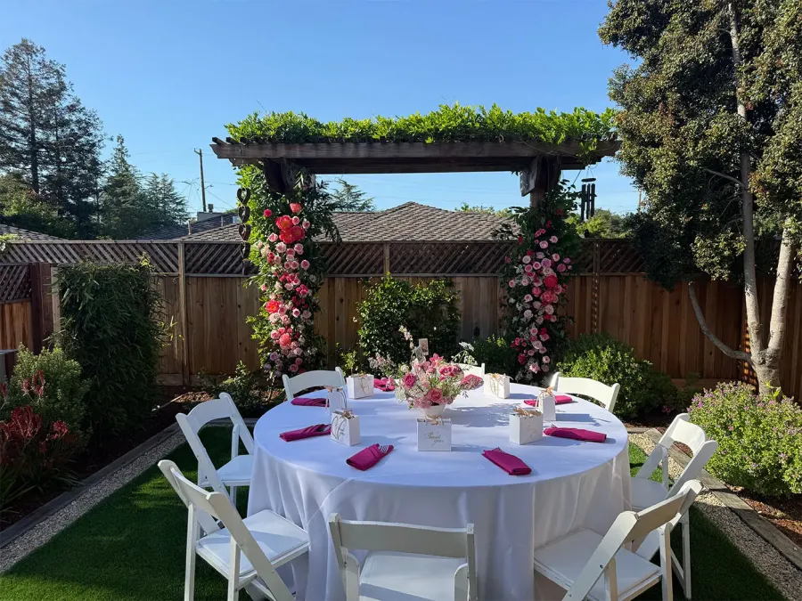 Pink and red rose floral arch over a linened table at a San Jose wedding, designed by San Jose Catering Company florals