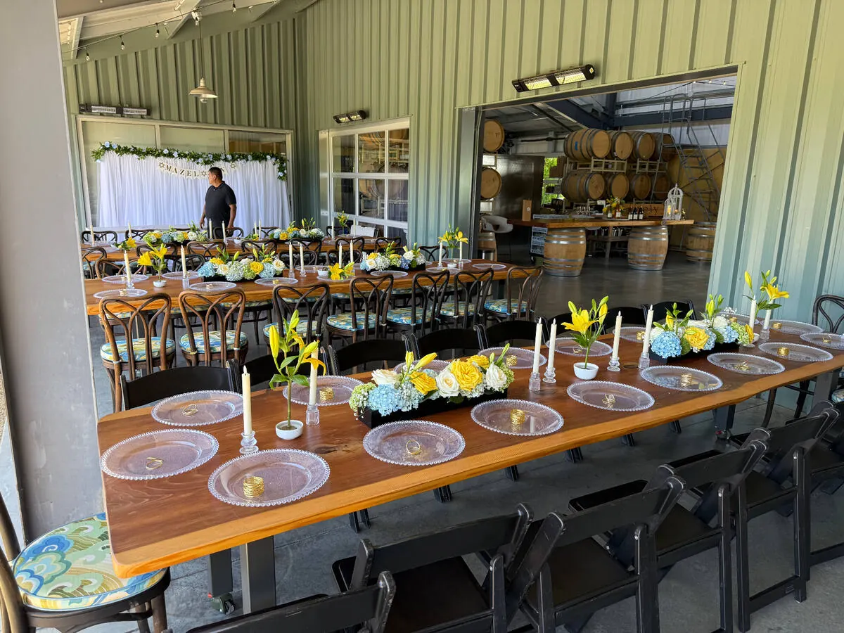 Table running with lily, hydrangea and rose arrangements between slim tapers down its length — centerpiece design for Los Gatos catering dinners