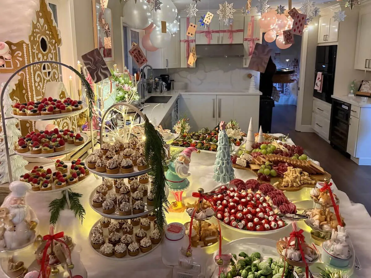 Celebration tablescape mixing tiered fruit tarts, cupcakes and charcuterie with pastel balloons and fresh stems — floral party styling in Campbell