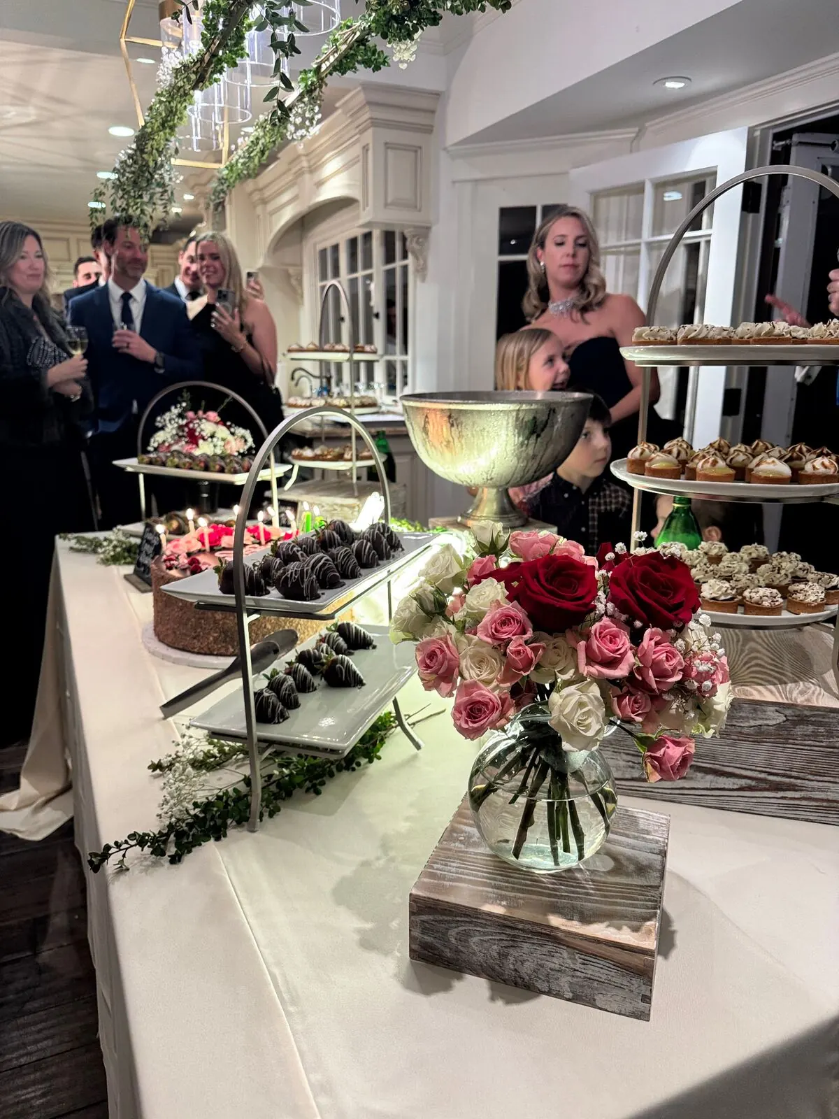 Wedding dessert table with tiered cake, tarts, and chocolate-dipped strawberries at a San Jose reception by San Jose Catering Company